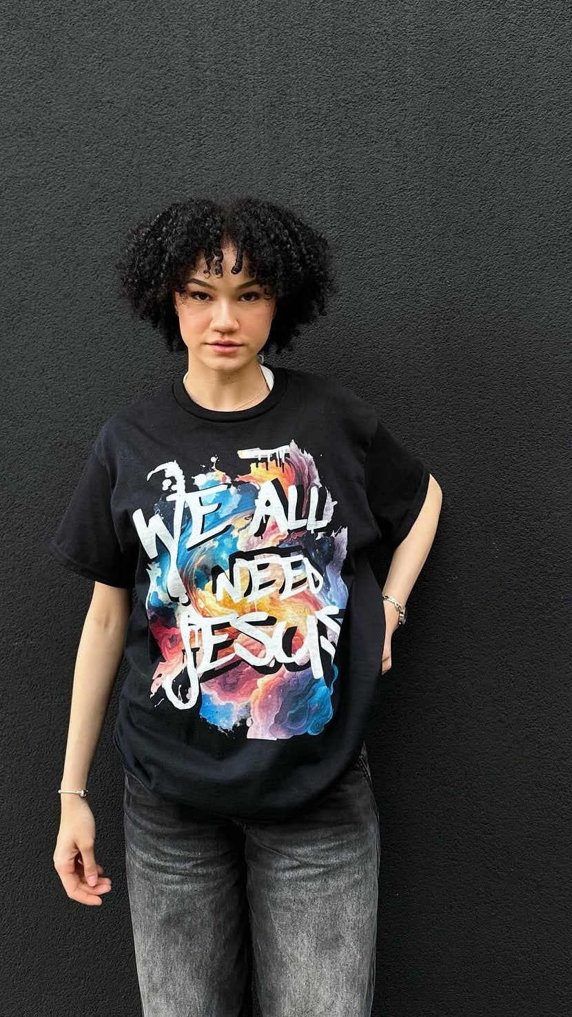 Person wearing a black t-shirt with colorful text design against a dark background